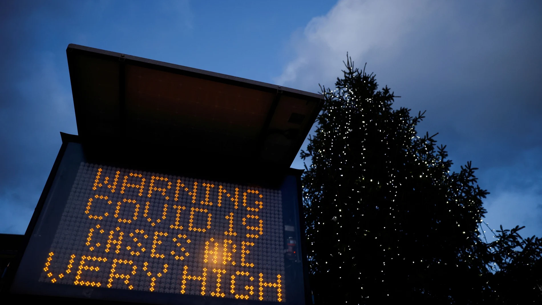 FILE PHOTO: An electronic sign displays information as the British government imposes a stricter tiered set of restrictions amid the coronavirus disease (COVID-19) pandemic, in London, Britain, December 20, 2020. REUTERS/John Sibley/File Photo