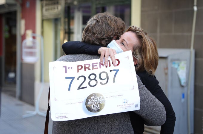 Dos mujeres se abrazan en la administración de lotería situada en la Avenida de Andalucía en la que se ha repartido parte del 72.897 del Gordo' de la Lotería de Navidad. Punta Umbría