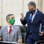 El consejero de la Presidencia, Elías Bendodo (d), conversa con el consejero de Hacienda, Juan Bravo (i), al inicio del pleno del Parlamento de Andalucía
