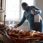 Un sacerdote ortodoxo regala un icono a un paciente de covid ingresado en el Hospital Santa Ana de Sofía, en Bulgaria