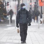 A man wears a face mask as he walks along Sainte-Catherine Street on Boxing Day in Montreal, Saturday, Dec. 26, 2020, as the COVID-19 pandemic continues in Canada and around the world. (Graham Hughes/The Canadian Press via AP)
