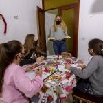 Cristina, en el salón de su casa de Sevilla junto a sus tres hijas, de 12 años la mayor y diez las mellizas