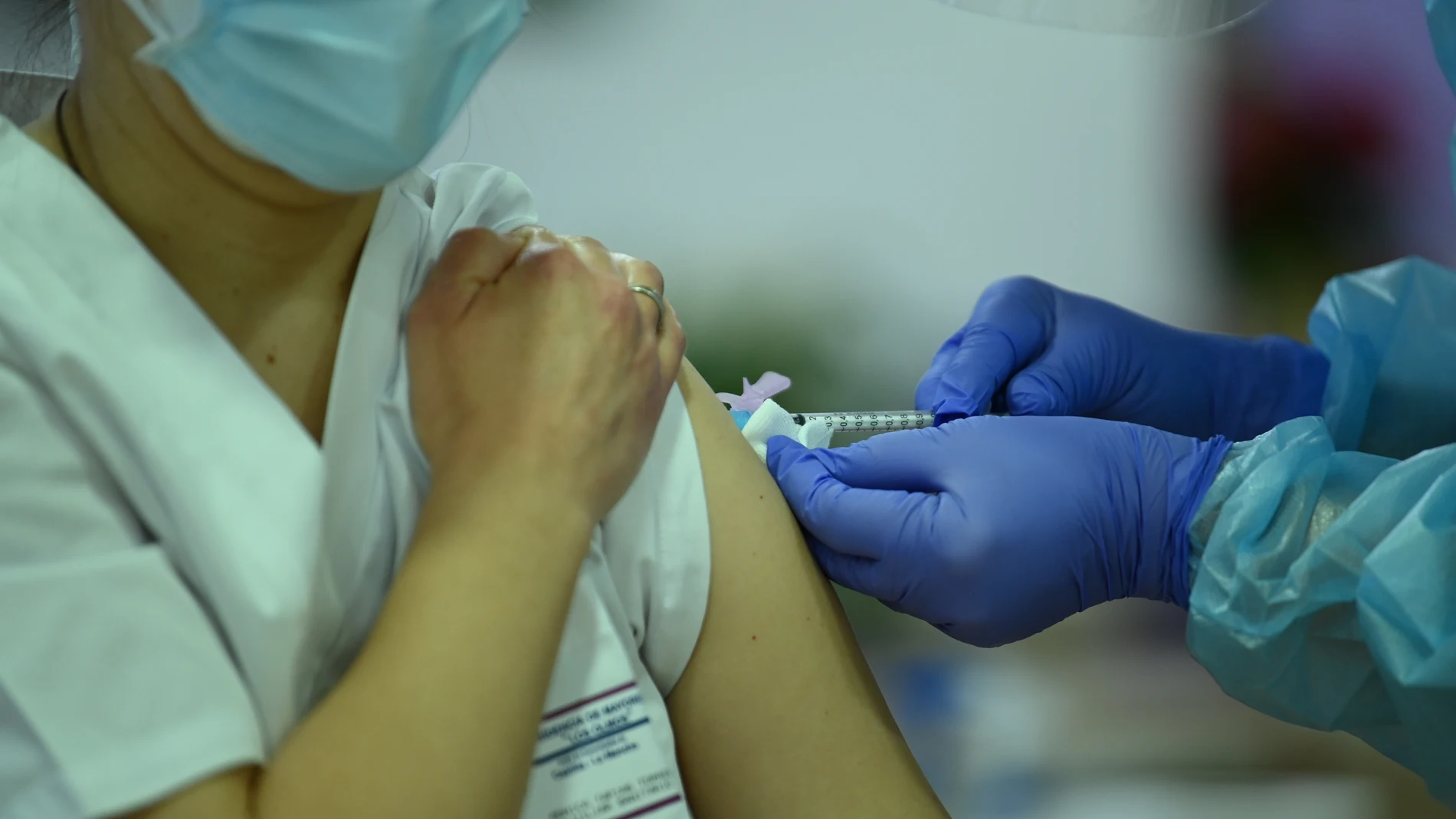 En la imagen, una auxiliar de enfermería recibe la vacuna contra la covid-19, administrada por una compañera