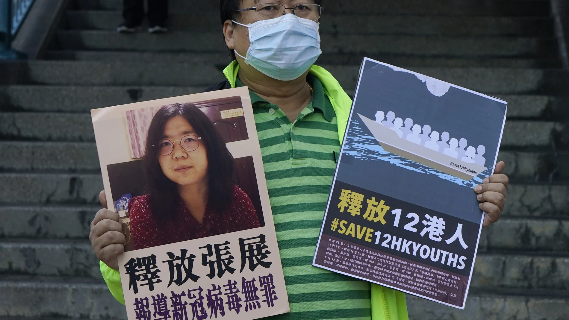 Un activista prodemocracia sostiene carteles con la foto de la periodista Zhang Zhan frente a la oficina del gobierno central chino, en Hong Kong