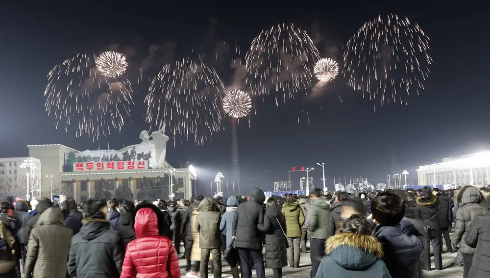 A fireworks display decorates the night sky to celebrate the New Year, as crowds of people look on, at Kim Il Sung Square in Pyongyang, North Korea, early Friday, Jan., 1, 2021. (AP Photo/Jon Chol Jin)