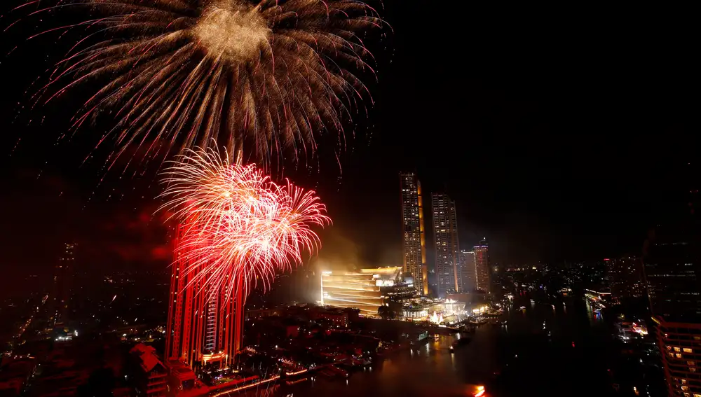 Bangkok (Thailand), 31/12/2020.- Fireworks illuminate the sky over Chao Phraya river after midnight during a New Year celebrations in Bangkok, Thailand, 01 January 2021. Thailand celebrates the 2021 New Year by a new-normal celebration with 25,000 eco-friendly fireworks made in Japan from Thai sticky rice. The new-normal celebrations is banned for public which will be broadcasted live via televise and social media under the strict health measures amid the fear of a new wave of COVID-19 coronavirus pandemic. (Incendio, Japón, Tailandia) EFE/EPA/RUNGROJ YONGRIT