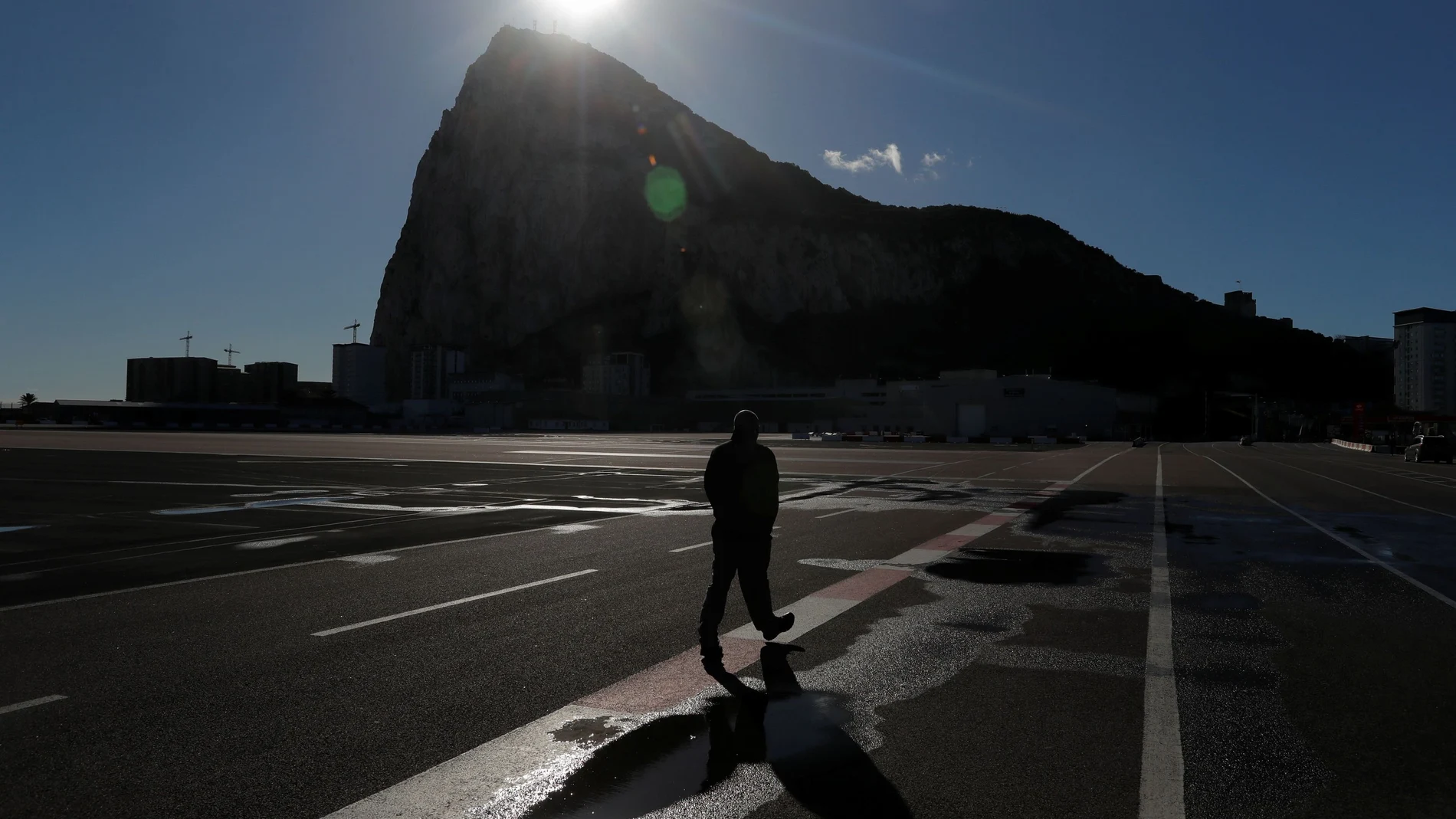 A man crosses the tarmac of the Gibraltar International Airport near the border between Gibraltar and Spain, following a post-Brexit deal, in Gibraltar, January 1, 2021. REUTERS/Jon Nazca