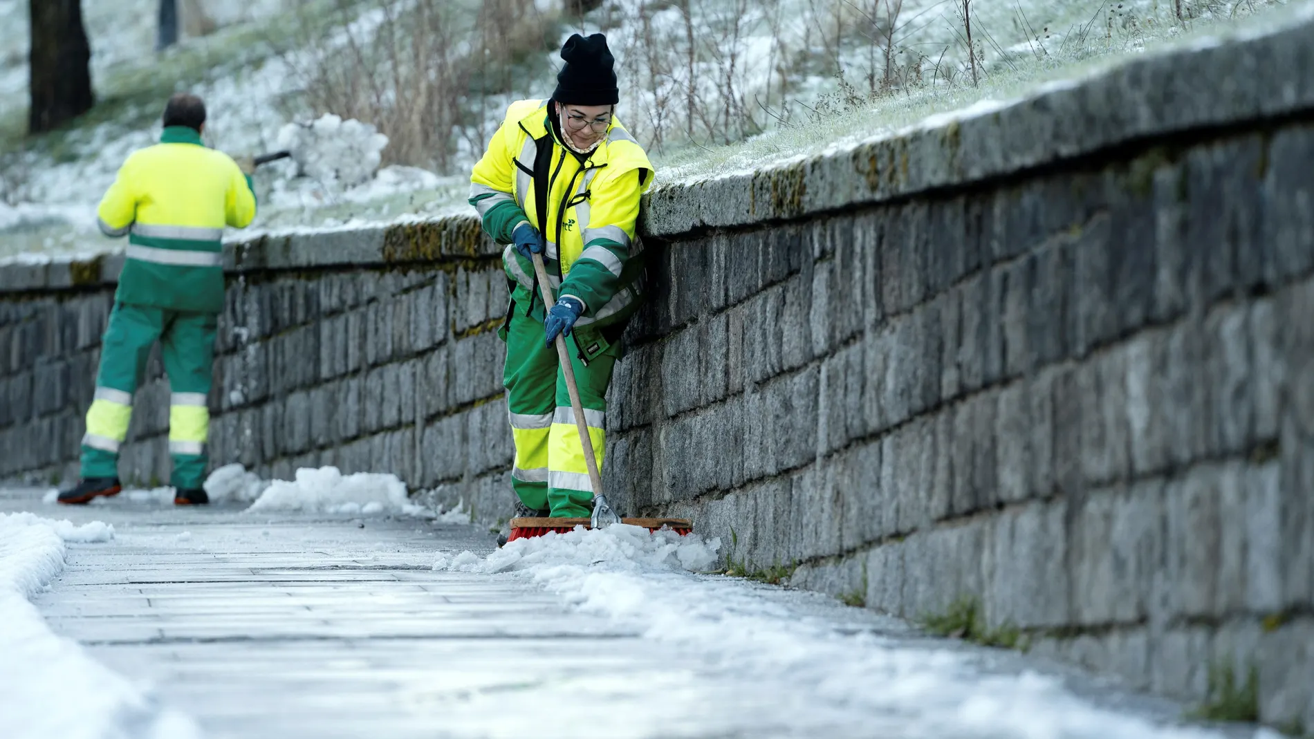 Operarios retiran la nieve y el hielo acumulado en las aceras en una calle de Ávila donde se han registrado temperaturas de 6,5 grados bajo cero durante la madrugada y primeras horas de la mañana. EFE/ Raúl Sanchidrián