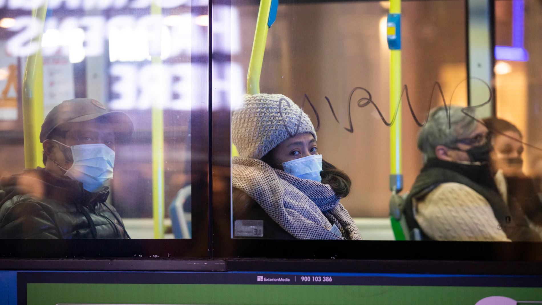 Pasajeros con mascarillas en un autobús que circula por las calles de Madrid