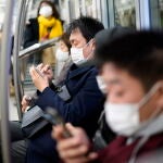 Tokyo (Japan), 06/01/2021.- Commuters wearing face masks sit in a subway coach in Tokyo, Japan, 06 January 2021. The Tokyo Metropolitan Government announced that it has confirmed over 1,500 new coronavirus infections in Tokyo, a new record figure. Following the surge in cases number, the government is considering declaring a state of emergency in Tokyo and three surrounding prefectures. (Japón, Tokio) EFE/EPA/FRANCK ROBICHON