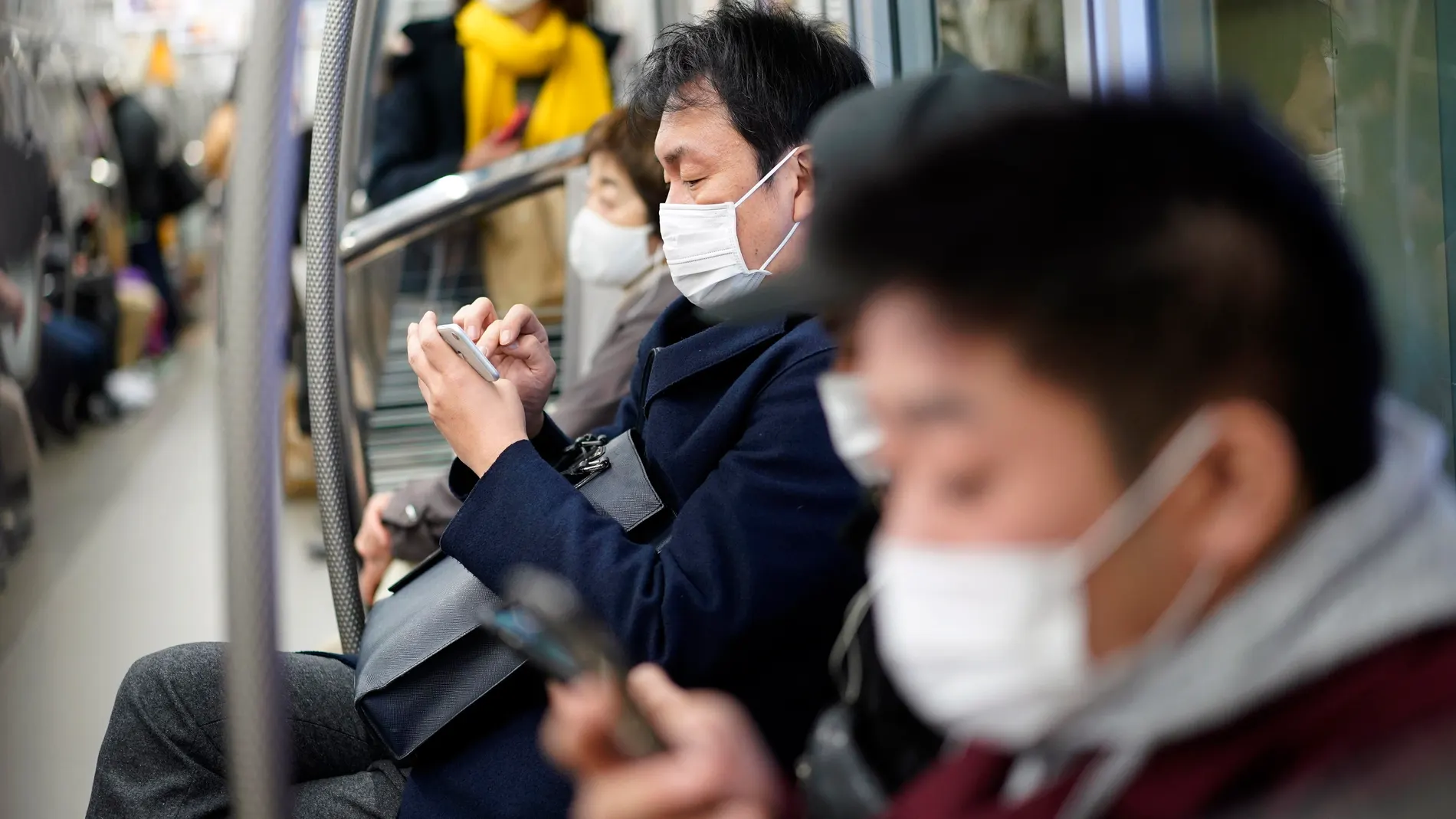 Tokyo (Japan), 06/01/2021.- Commuters wearing face masks sit in a subway coach in Tokyo, Japan, 06 January 2021. The Tokyo Metropolitan Government announced that it has confirmed over 1,500 new coronavirus infections in Tokyo, a new record figure. Following the surge in cases number, the government is considering declaring a state of emergency in Tokyo and three surrounding prefectures. (Japón, Tokio) EFE/EPA/FRANCK ROBICHON