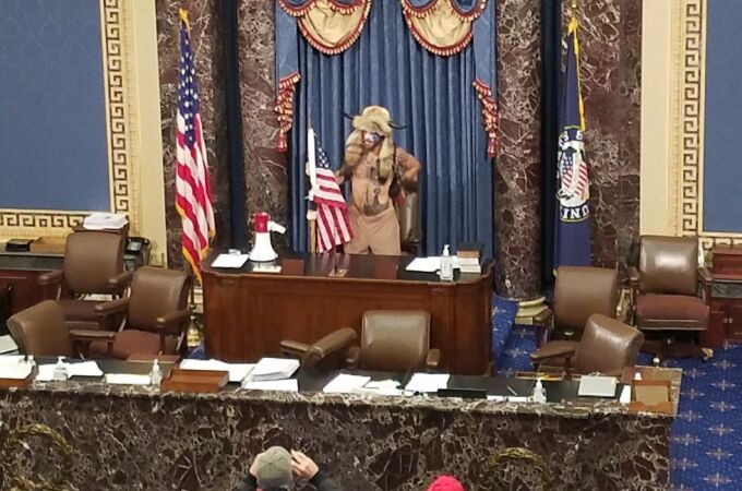 Un hombre con cuernos de bisonte en el sillón de la presidenta del Senado