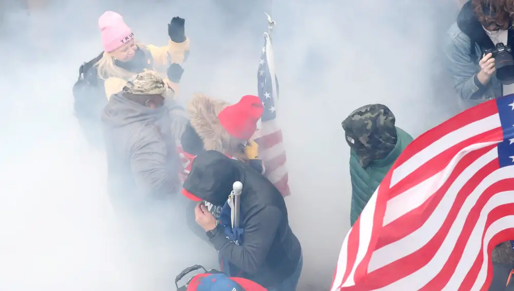 FILE PHOTO: Pro-Trump protesters react amidst a cloud of tear gas during clashes with Capitol police at a rally to contest the certification of the 2020 U.S. presidential election results by the U.S. Congress, at the U.S. Capitol Building in Washington, U.S, January 6, 2021. REUTERS/Shannon Stapleton/File Photo