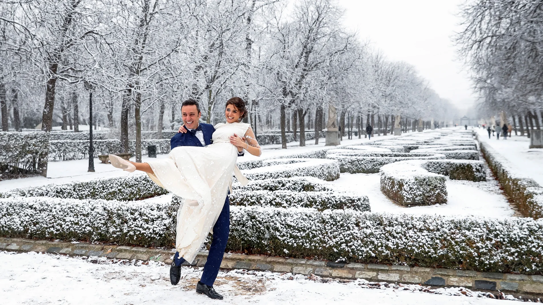 Los recién casados Julio y Yone posan en el parque del Retiro durante una nevada este jueves en Madrid.