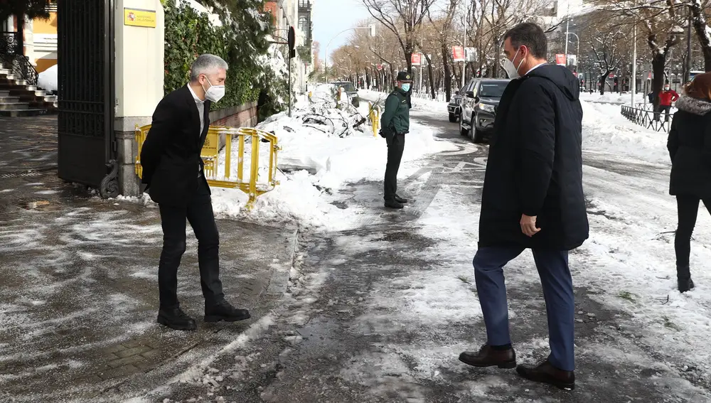 El ministro de interior, Grande-Marlaska (izda.), viste de traje de chaqueta, pero se resguarda del frío con jersey y botas