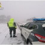 Un agente de la Guardia Civil presta servicio en una carretera nevada