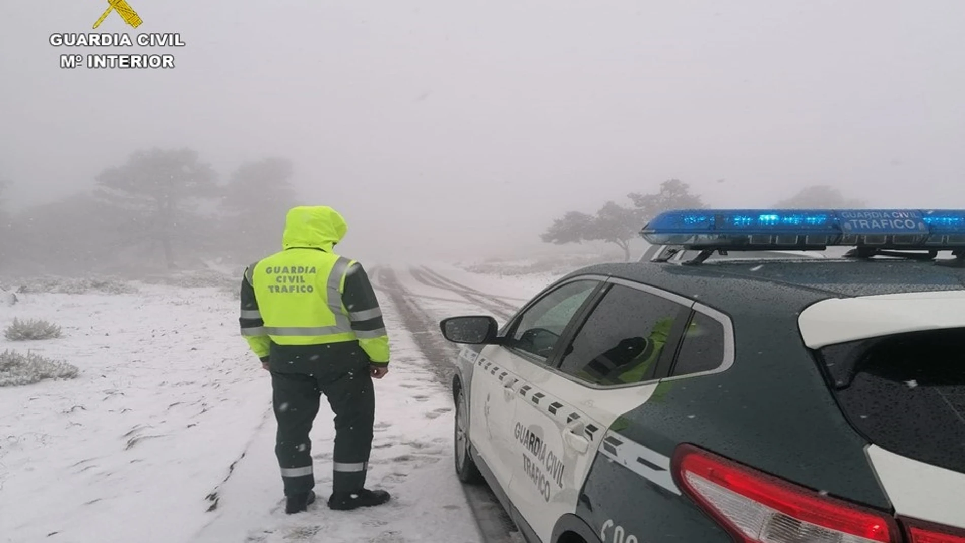 Un agente de la Guardia Civil presta servicio en una carretera nevada
