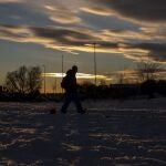 Un hombre camina al atardecer en Rivas Vaciamadrid antes del desplome de temperaturas que se prevé a partir de esta noche.