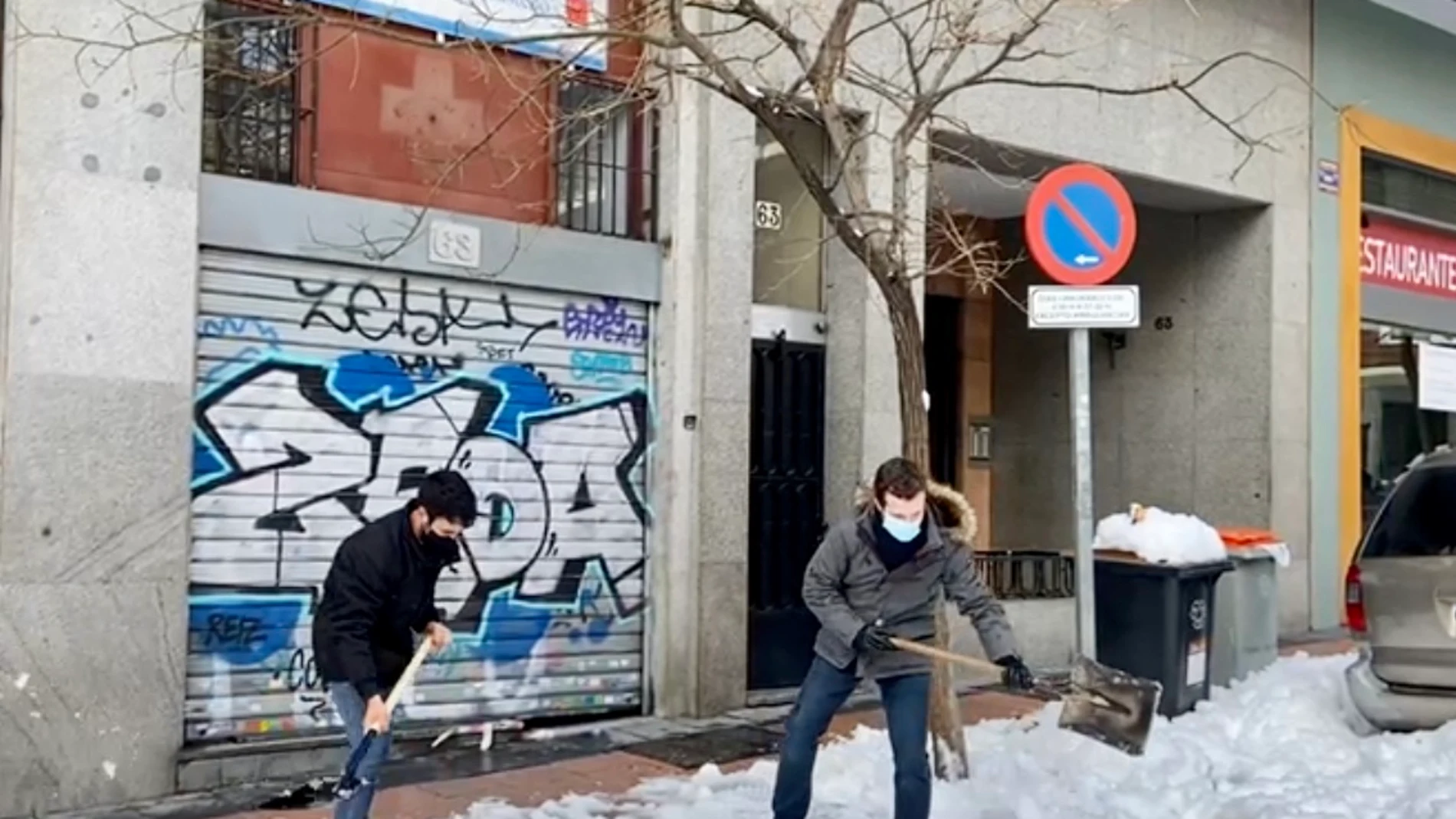 El líder del PP, Pablo Casado retirando la nieve de las puertas de un centro de Salud