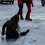 Una mujer cae en el suelo después de resbalar con el hielo ayer en Madrid.