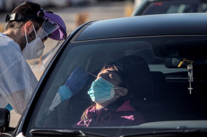 Un sanitario realiza test para detectar la covid-19 a pacientes en sus vehículos frente al hospital de campaña de La Fe de València