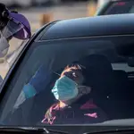 Un sanitario realiza test para detectar la covid-19 a pacientes en sus vehículos frente al hospital de campaña de La Fe de València