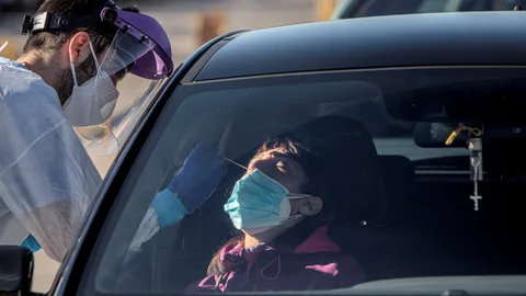 Un sanitario realiza test para detectar la covid-19 a pacientes en sus vehículos frente al hospital de campaña de La Fe de València