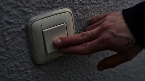 Un hombre toca una llave de la luz en Madrid (España)