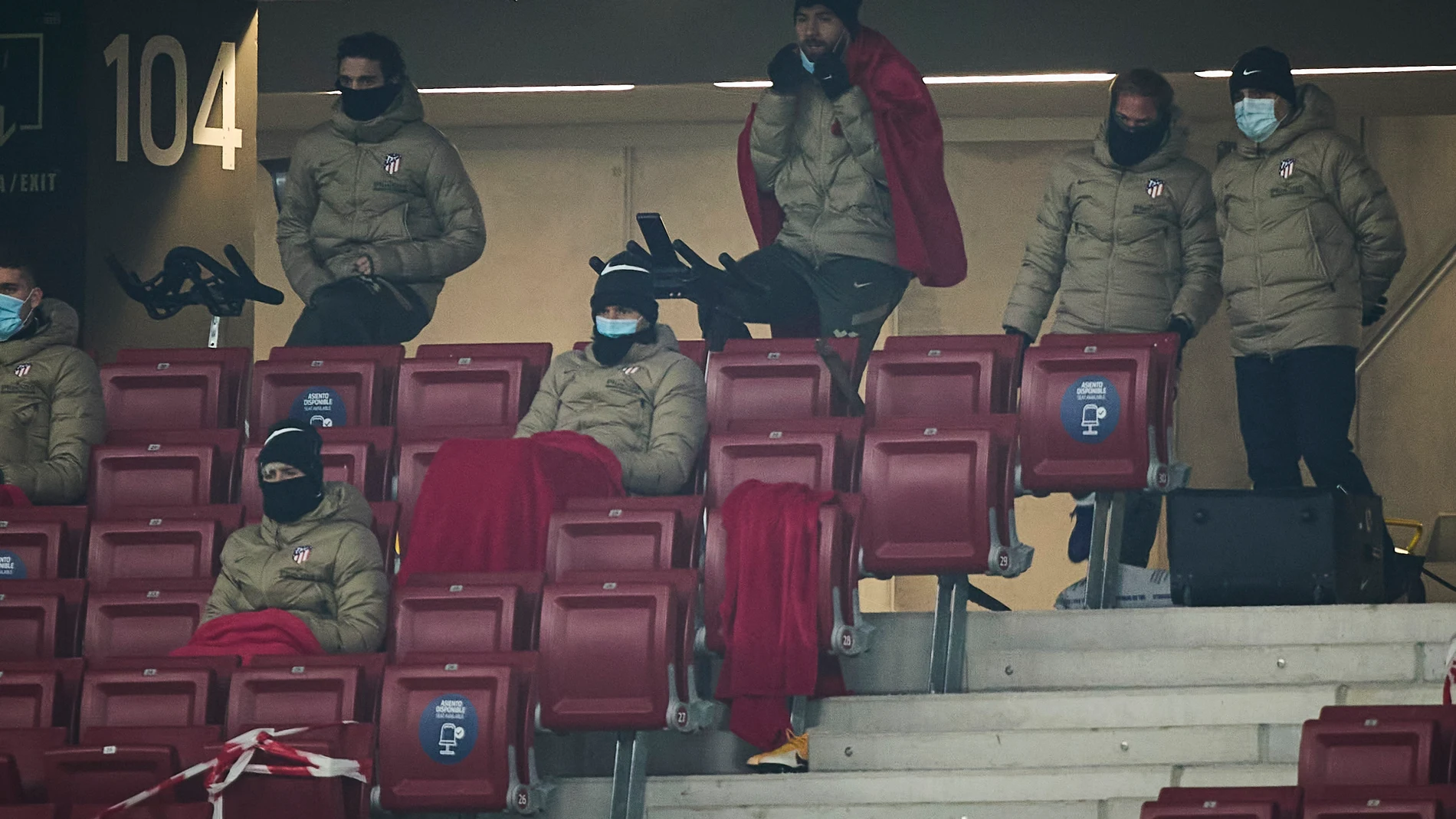 Los Jugadores suplentes del Atlético combaten el frío con bicicletas estáticas durante el encuentro de futbol de La Liga Santander que enfrenta al Atlético de Madrid y al Sevilla en el estadio Wanda Metropolitano