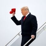 El presidente saliente de EE UU, Donald Trump, saluda con su mítica gorra de MAGA