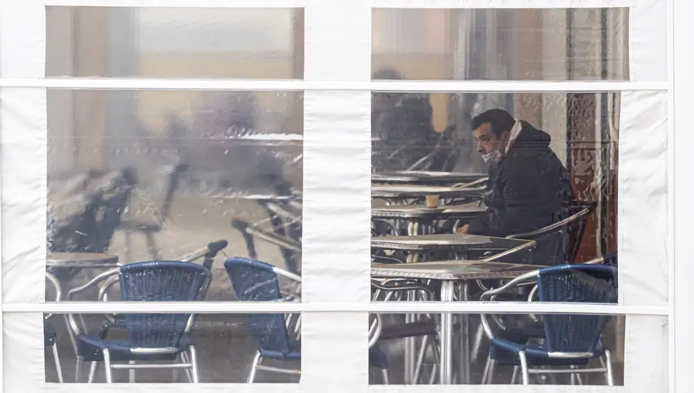 VALLADOLID, 14/01/2021.- Un cliente se toma un café en la terraza de un bar este jueves en Valladolid. Toda Castilla y León está desde la pasada medianoche y hasta el 26 de enero con medidas más restrictivas para intentar frenar la curva de la tercera ola de la pandemia, con el cierre del interior de bares y restaurantes, de los grandes establecimientos comerciales y de instalaciones deportivas cubiertas. EFE/R. García
