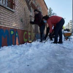 Varios familiares colaboran en la limpieza del hielo y la nieve en las inmediaciones del colegio Amadeo Vives tras la gran nevada