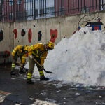 Varios militares de las Brigadas de Refuerzo de Incendios Forestales (BRIF) colaboran durante el segundo día de limpieza del hielo y nieve en las inmediaciones de un colegio tras la gran nevada