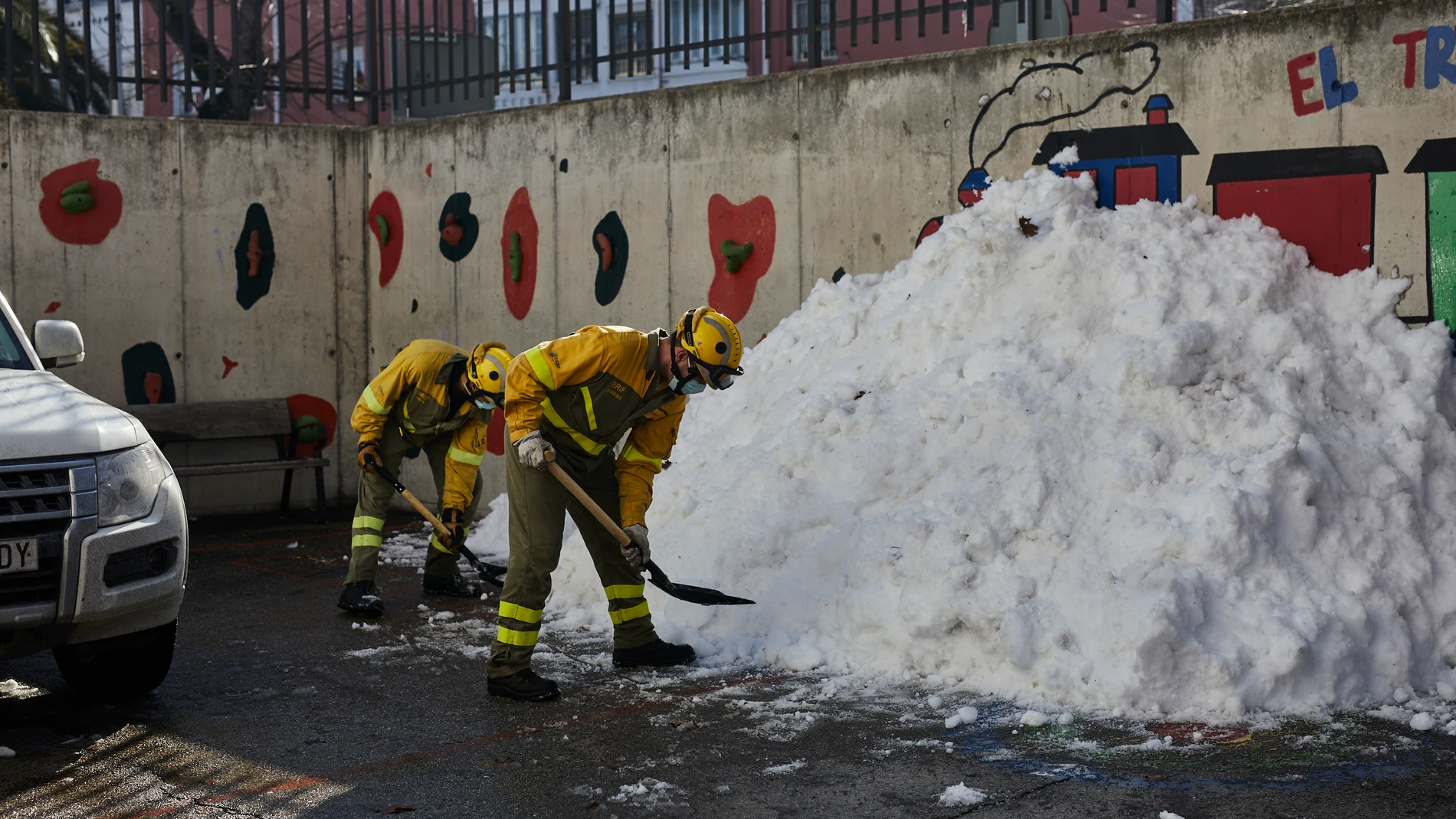 Varios militares de las Brigadas de Refuerzo de Incendios Forestales (BRIF) colaboran durante el segundo día de limpieza del hielo y nieve en las inmediaciones de un colegio tras la gran nevada