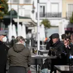 Cuatro personas en la terraza de un bar en Sevilla