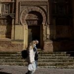 DOs personas caminan junto a la Mezquita-Catedral de Córdoba