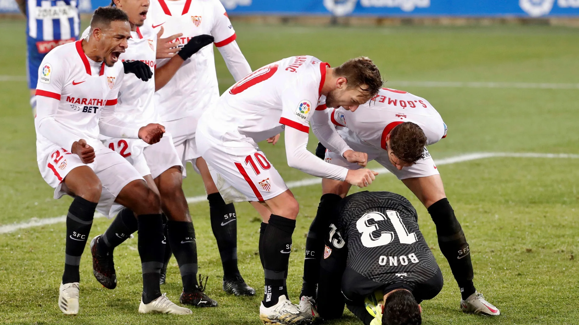 El guardameta marroquí del Sevilla, Yassine Bounou, felicitado por sus compañeros tras detener un penalti durante el encuentro correspondiente a la jornada 19 de la Liga Santander. EFE/ David Aguilar.