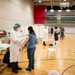 Empleados sanitarios vacunan a una compañera de profesión contra el Covid-19 en el pabellón Cabezo Baeza de Cartagena, en Murcia