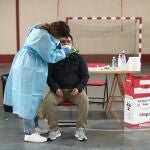Una trabajadora sanitaria protegida realiza uno de los primeros test de antígenos de SARS-CoV-2 en Vallecas