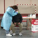 Una trabajadora sanitaria protegida realiza uno de los primeros test de antígenos de SARS-CoV-2 en Vallecas