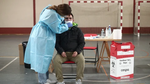 Una trabajadora sanitaria protegida realiza uno de los primeros test de antígenos de SARS-CoV-2 en Vallecas
