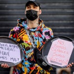 Un trabajador con cárteles durante la cacerolada contra el cierre de la hostelería en la Comunidad Valenciana