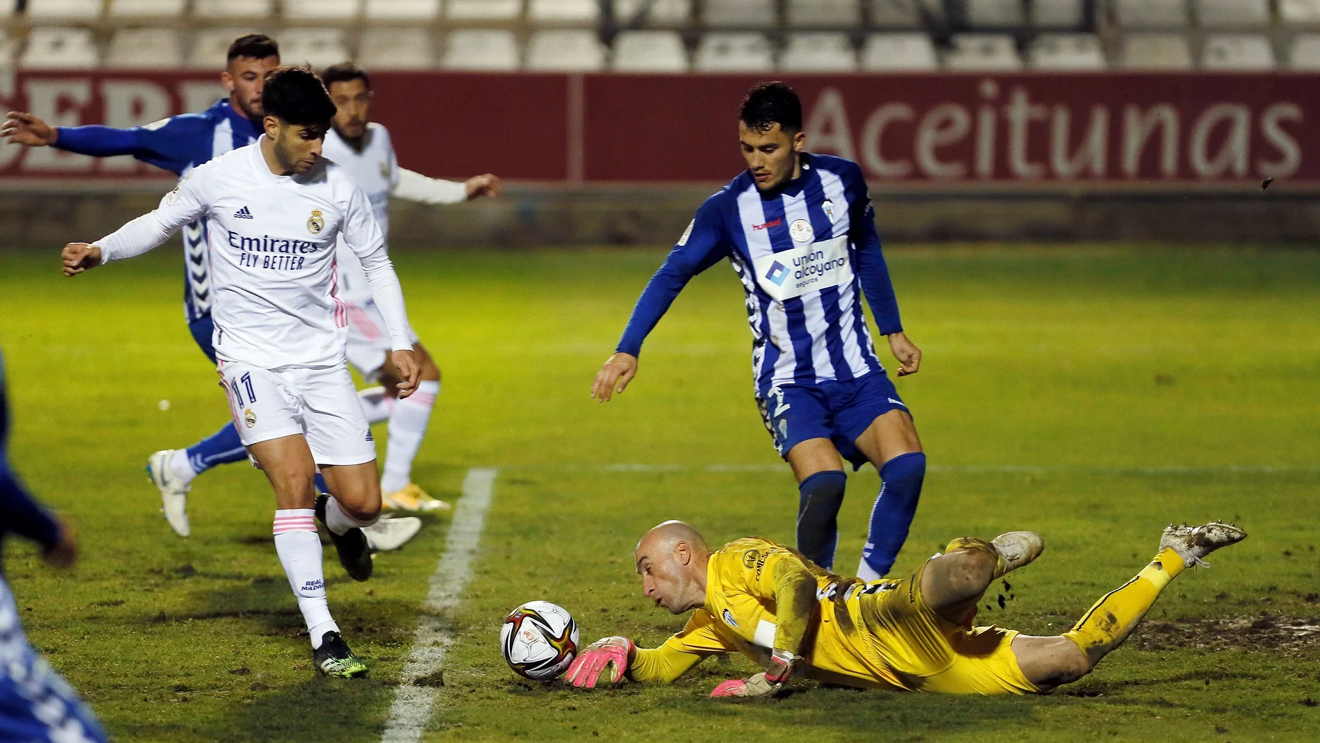 El guardameta del Alcoyano, José Juan (d), detiene un balón ante el centrocampista del Real Madrid, Marco Asensio durante el Alcoyano-Real Madrid