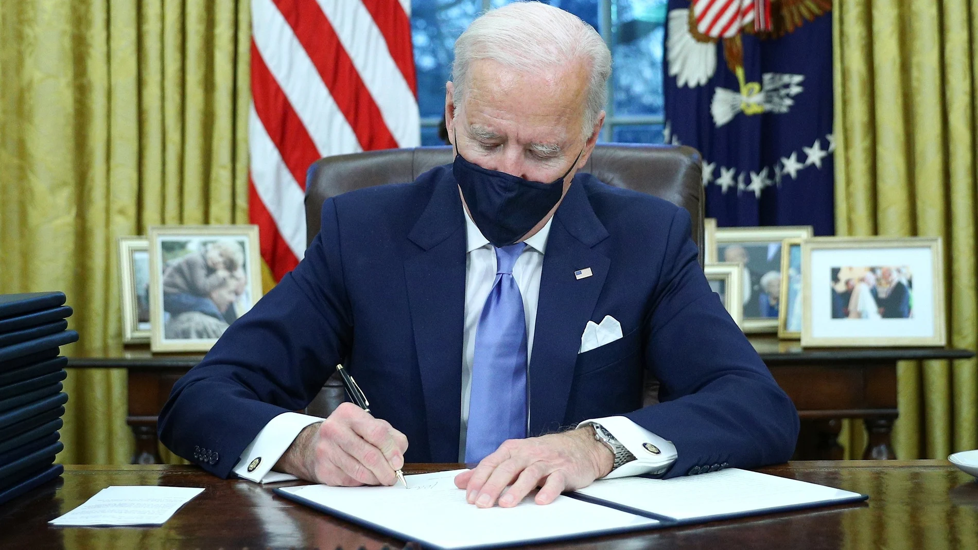 Joe Biden firma las primeras medidas de su mandato ya en su despacho de la Casa Blanca.