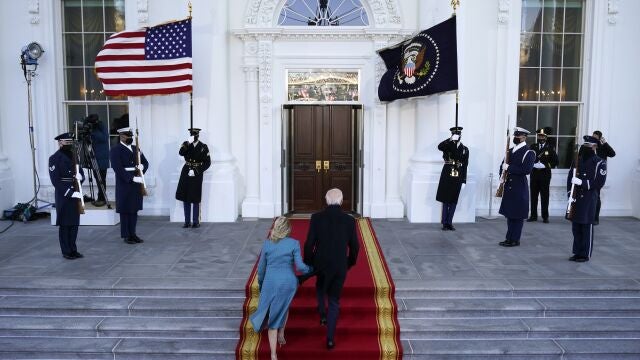 El presidente Joe Biden y la primera dama Jill Biden suben las escaleras del pórtico norte de la Casa Blanca