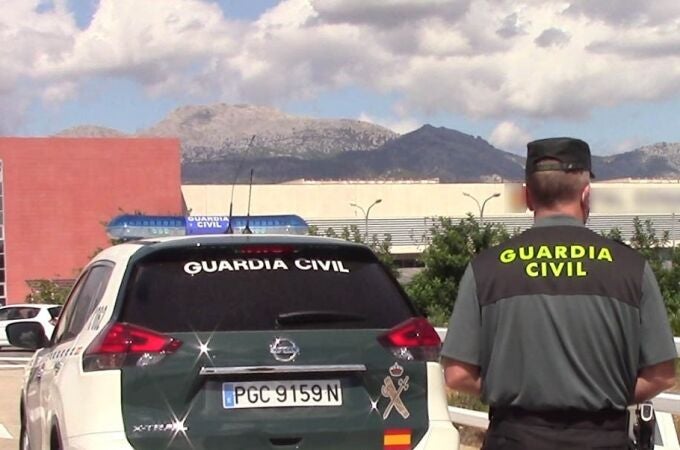 Un vehículo de la Guardia Civil y un agente de espaldas