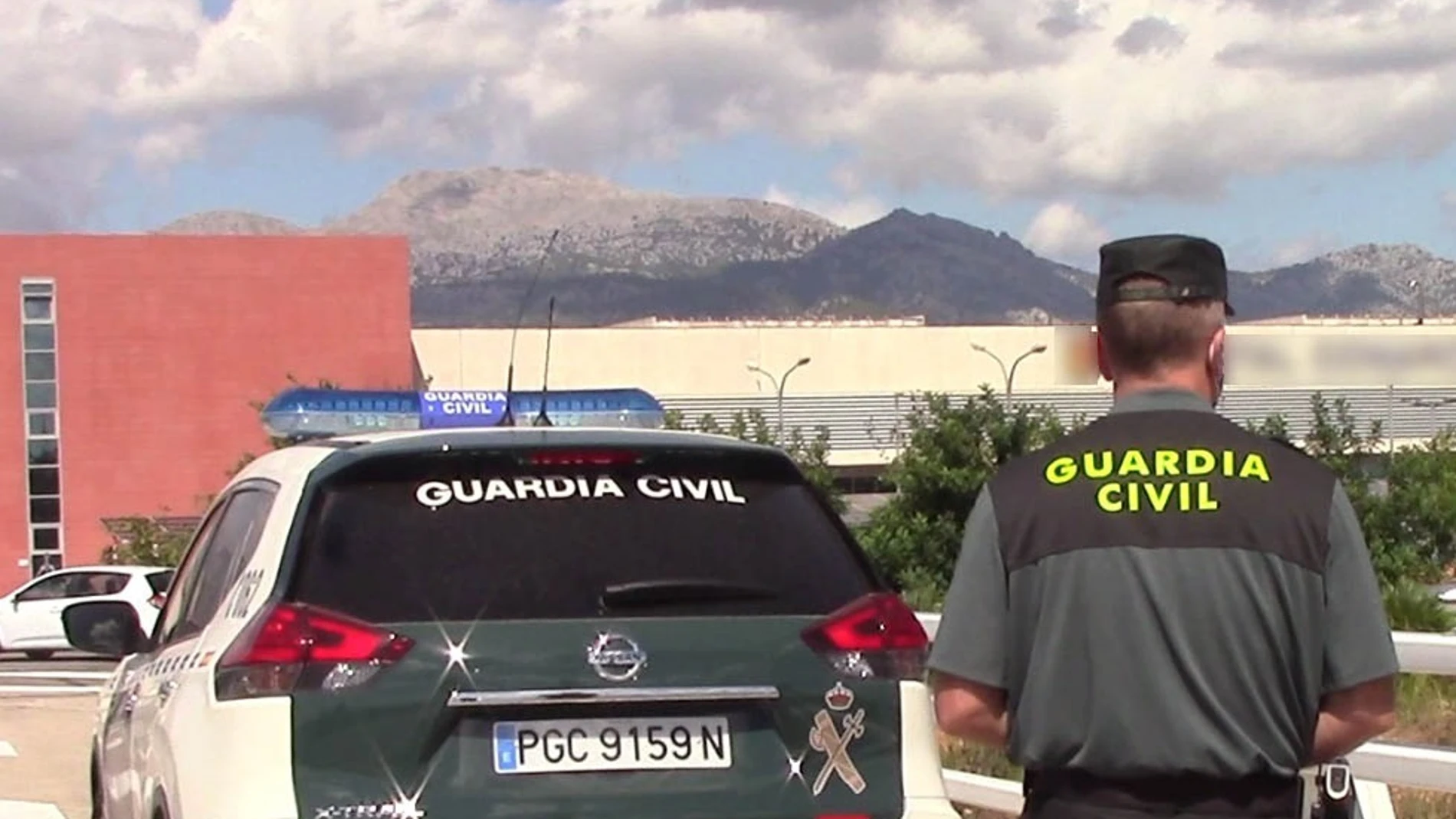 Un vehículo de la Guardia Civil y un agente de espaldas