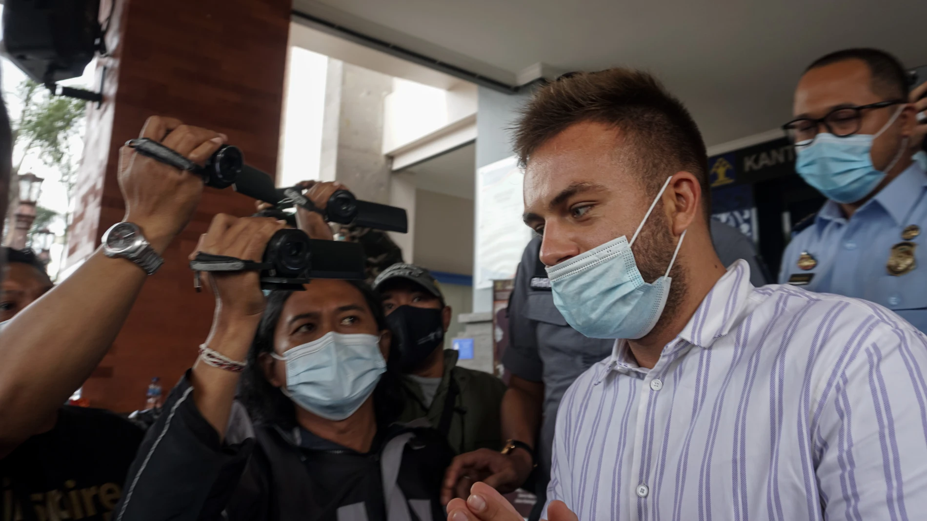 24 January 2021, India, Badung: Immigration officers escort Russian social media influencer Sergei Kosenko to the airport before being deported after he attended a party with 50 people and thus violating COVID-19 health protocols. Photo: Dicky Bisinglasi/ZUMA Wire/dpa24/01/2021 ONLY FOR USE IN SPAIN