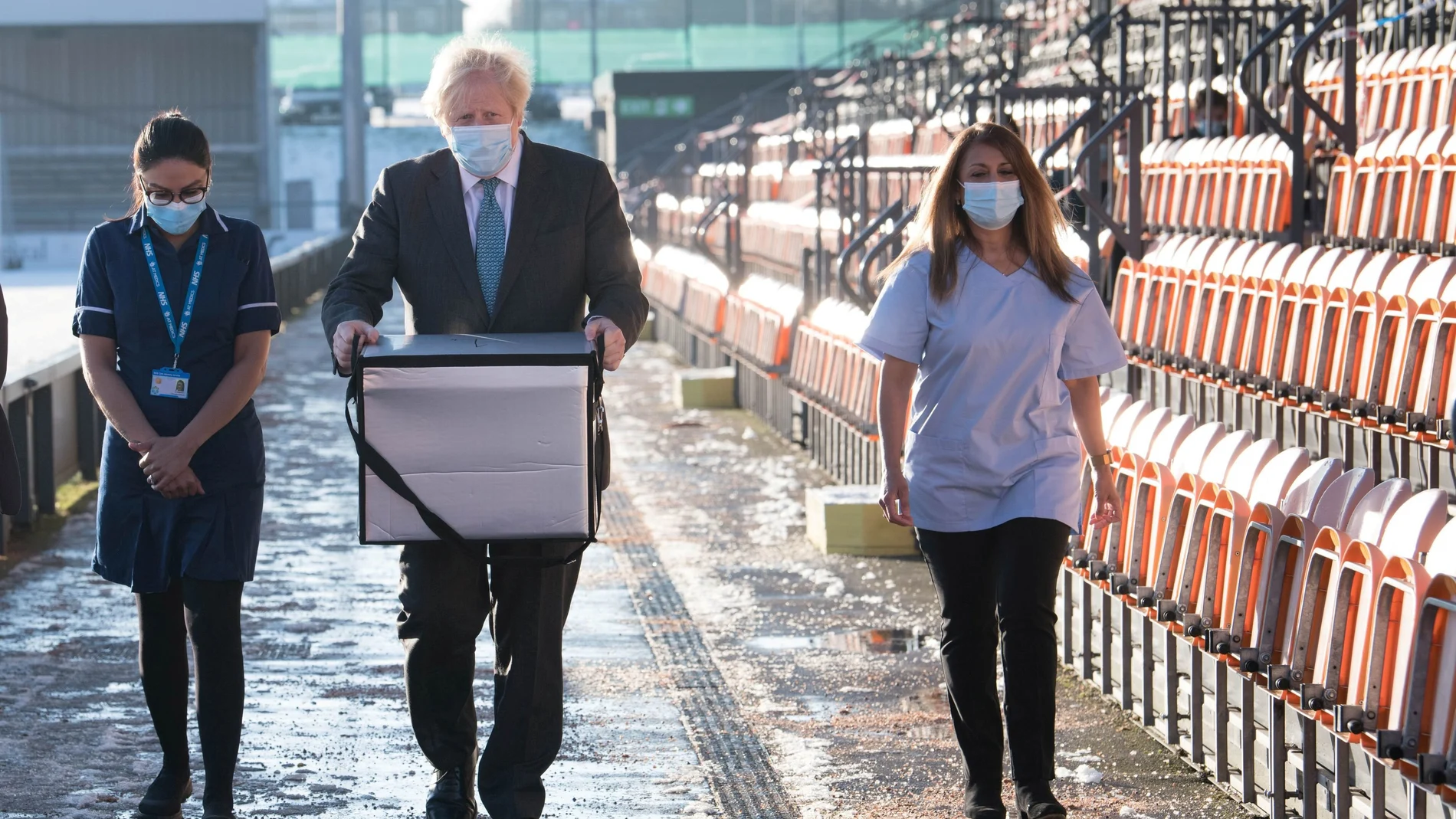 El primer ministro británico, Boris Johnson, carga con una caja de dosis de la vacuna Oxford / AstraZeneca para su distribución móvil en el norte de Londres