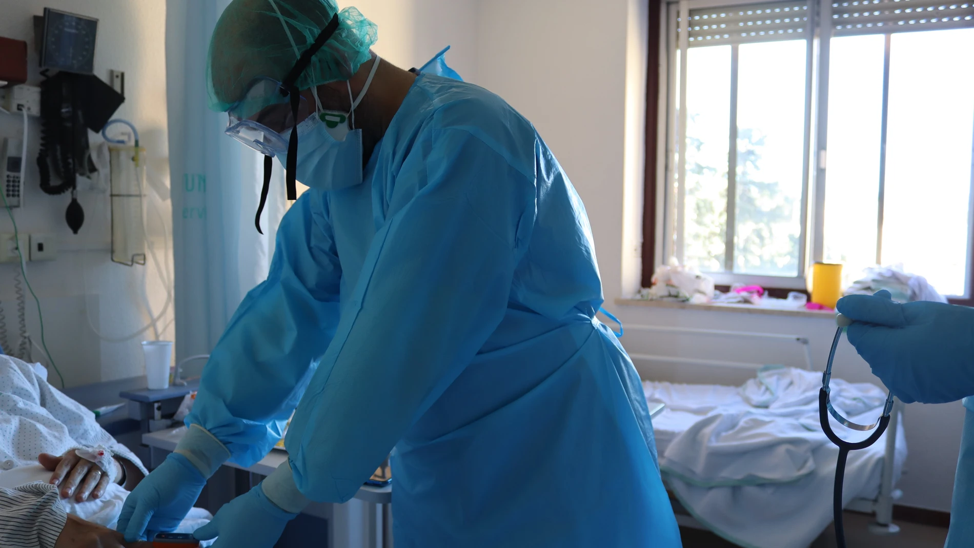 Un sanitario atiende a un enfermo en el Hospital Regional de Málaga